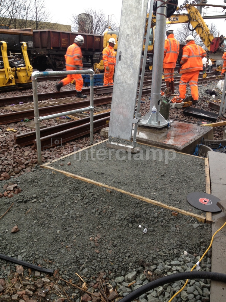 Modular balustrade safety post system assembled with Interclamp key/tube clamp fittings along a railway, creating a protective barrier for personnel in a high-risk environment.